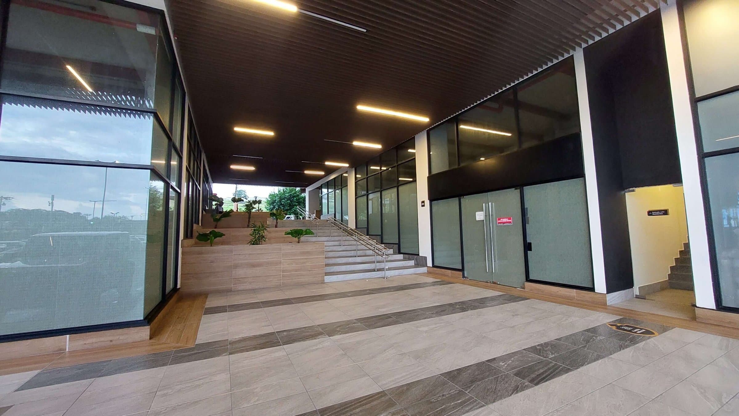 Greenwood Plaza interior corridor with glass storefronts and stairs