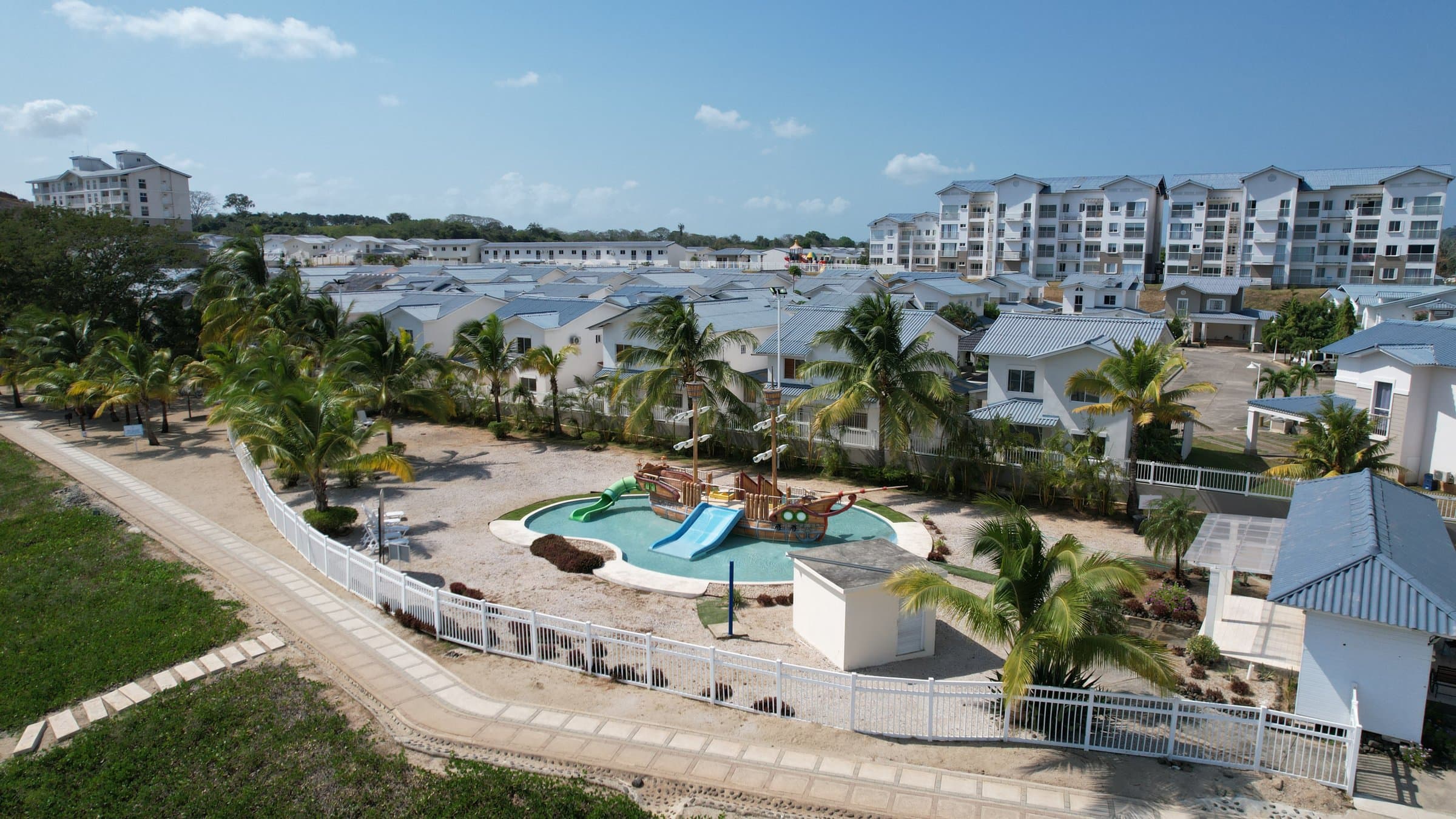 Playa Dorada houses and apartment buildings around a community pool with a water slide