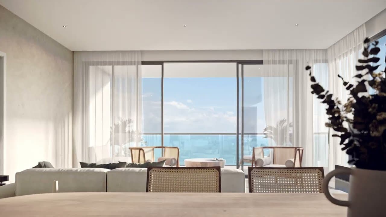 Rendering of an apartment living and dining room at The Palms Beach Resort with sheer curtains and an ocean-view balcony