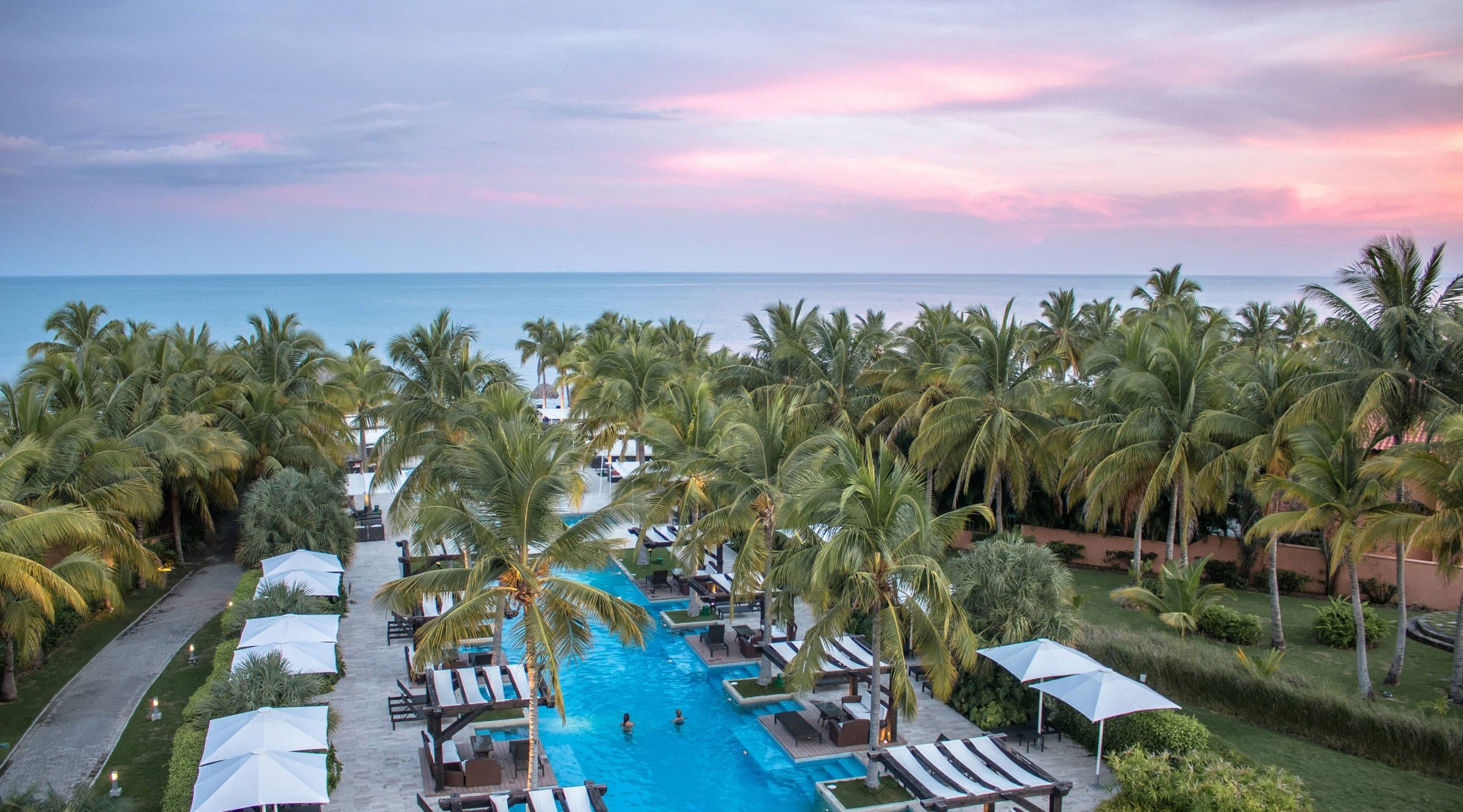 Aerial view of the Buenaventura beach club pool among palm trees
