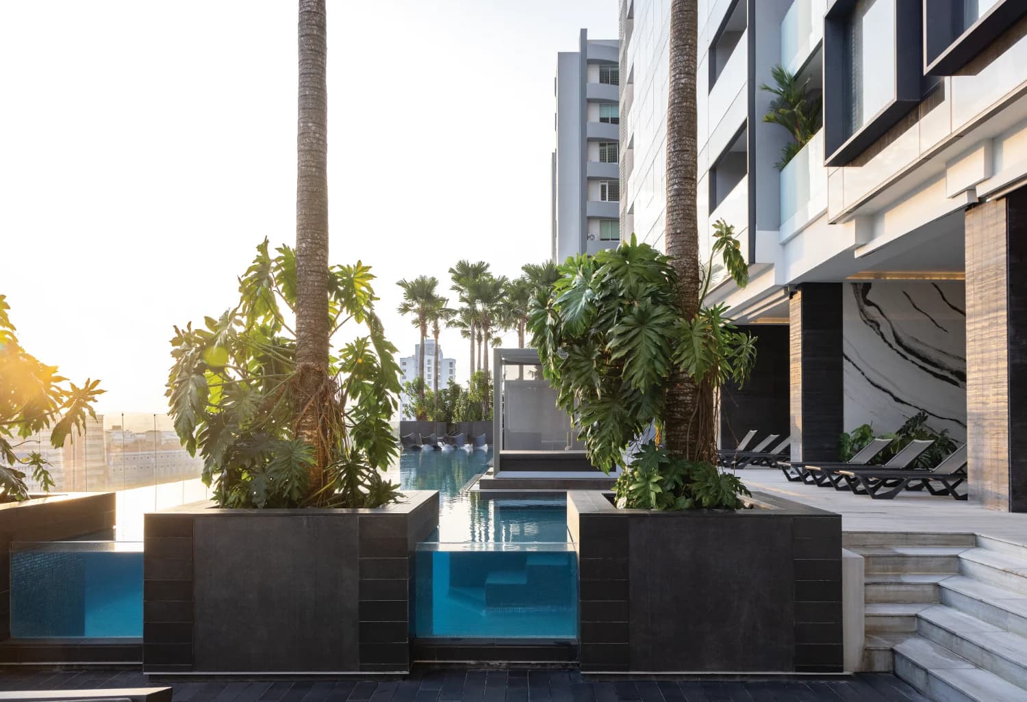 Nuovo by Armani/Casa pool deck with glass-sided pool and tropical planters