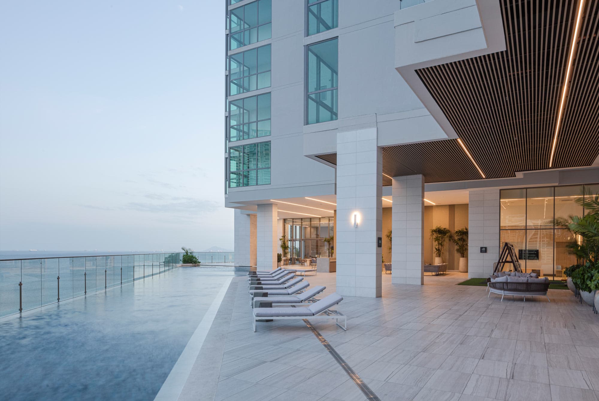 Infinity pool deck with sun loungers and ocean views at Sea Point