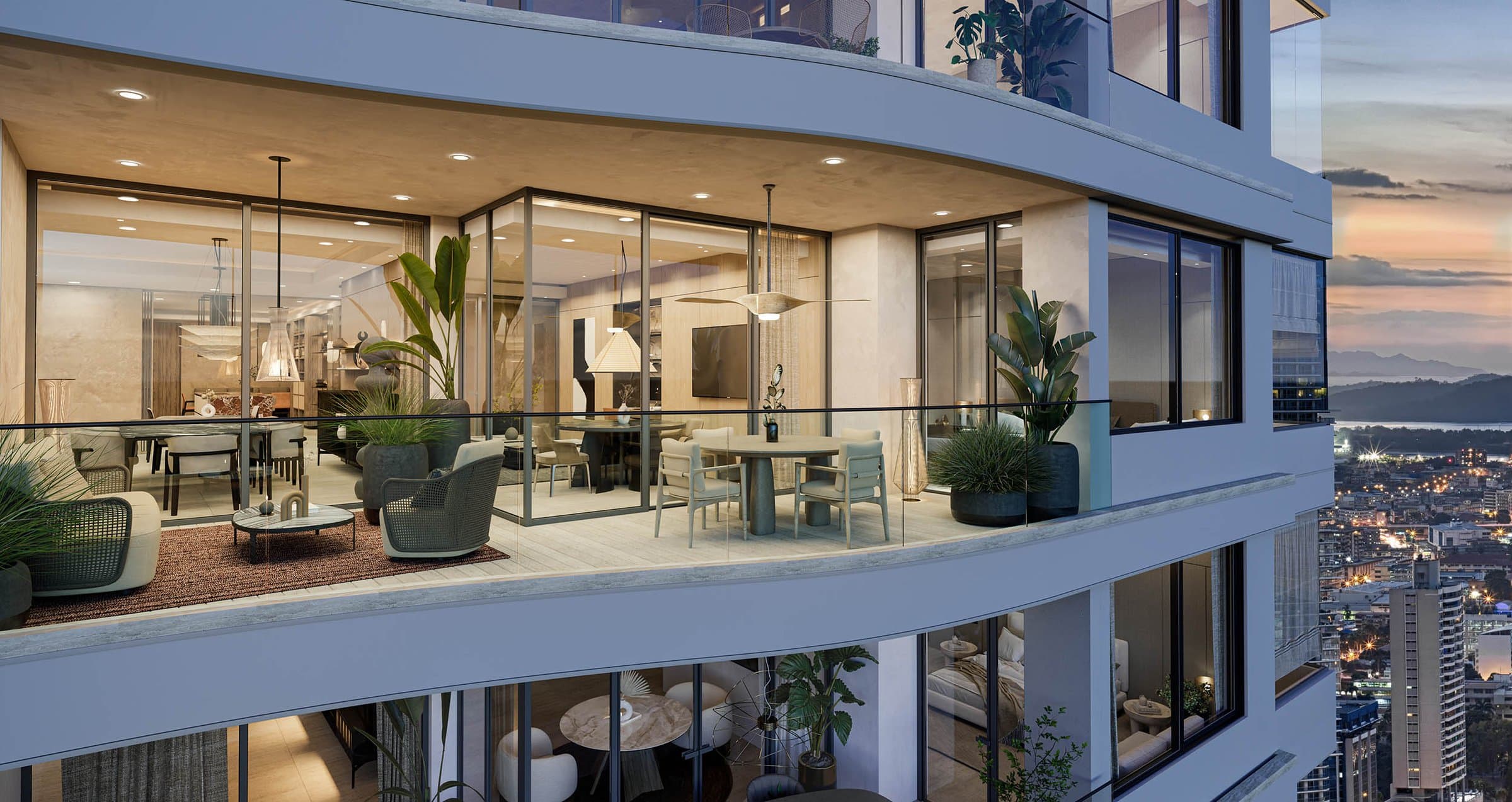 Wraparound glass balcony with lounge seating at a Tagua apartment at dusk