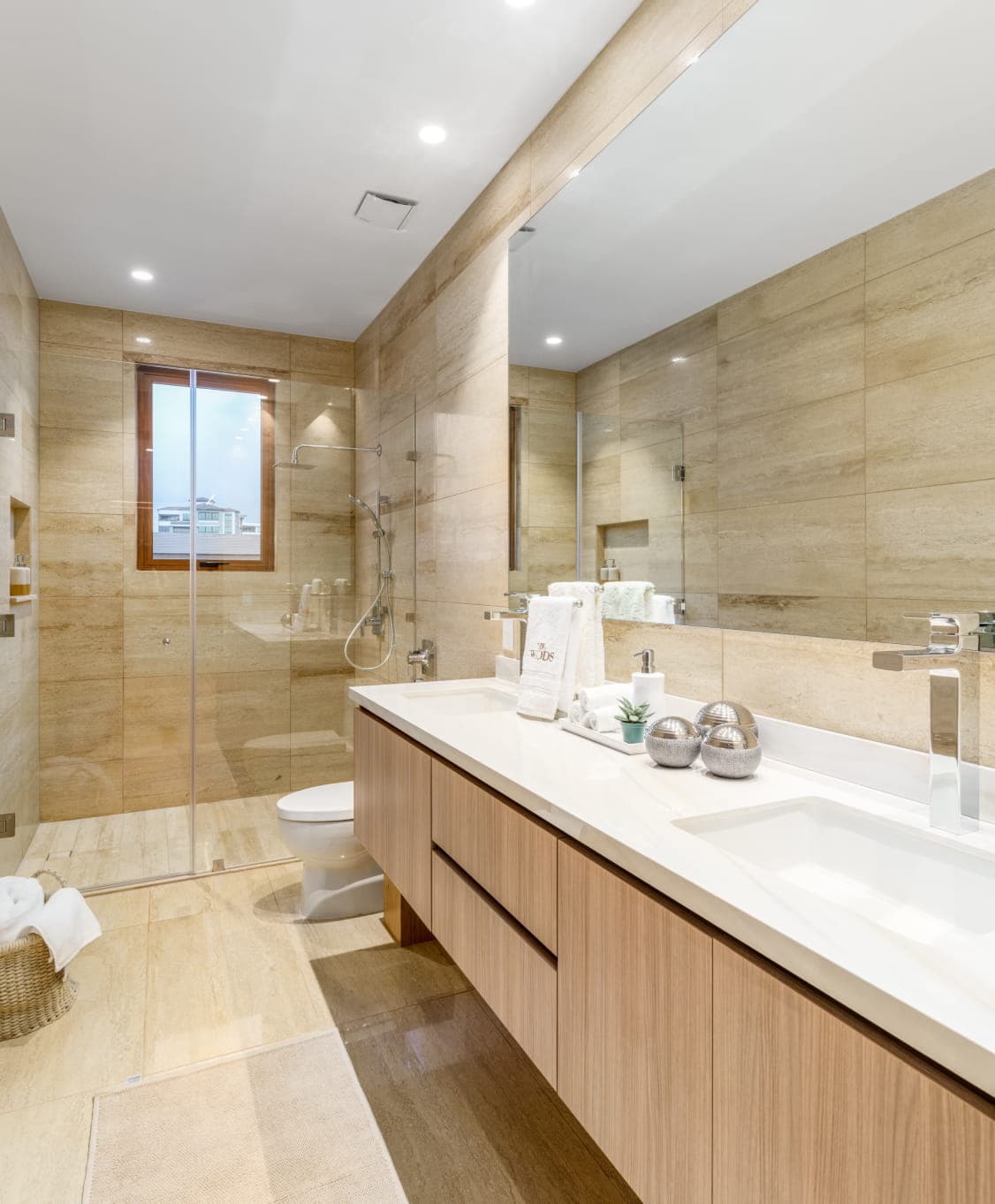 Primary bathroom with double vanity and walk-in shower at The Woods