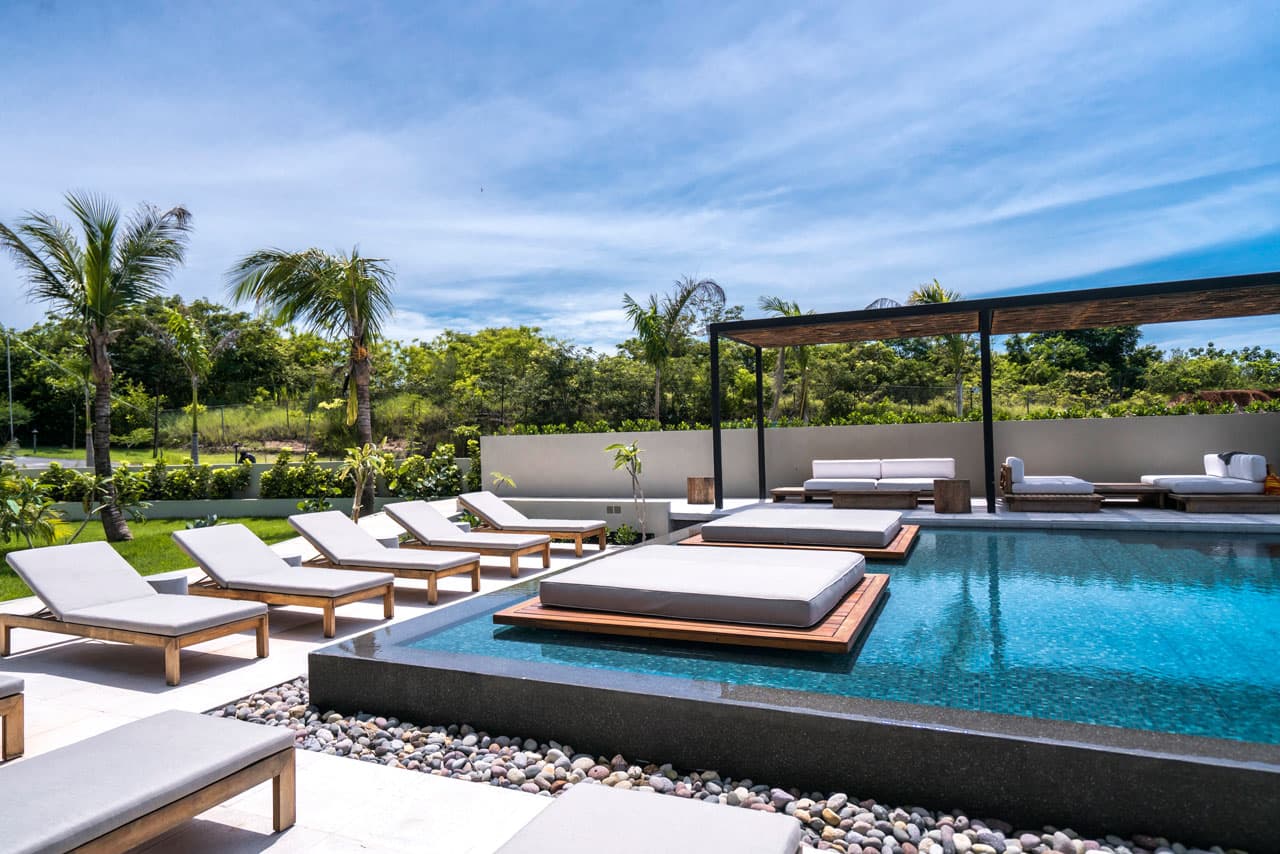 Pool deck with sun beds and a shaded pergola at Solaria