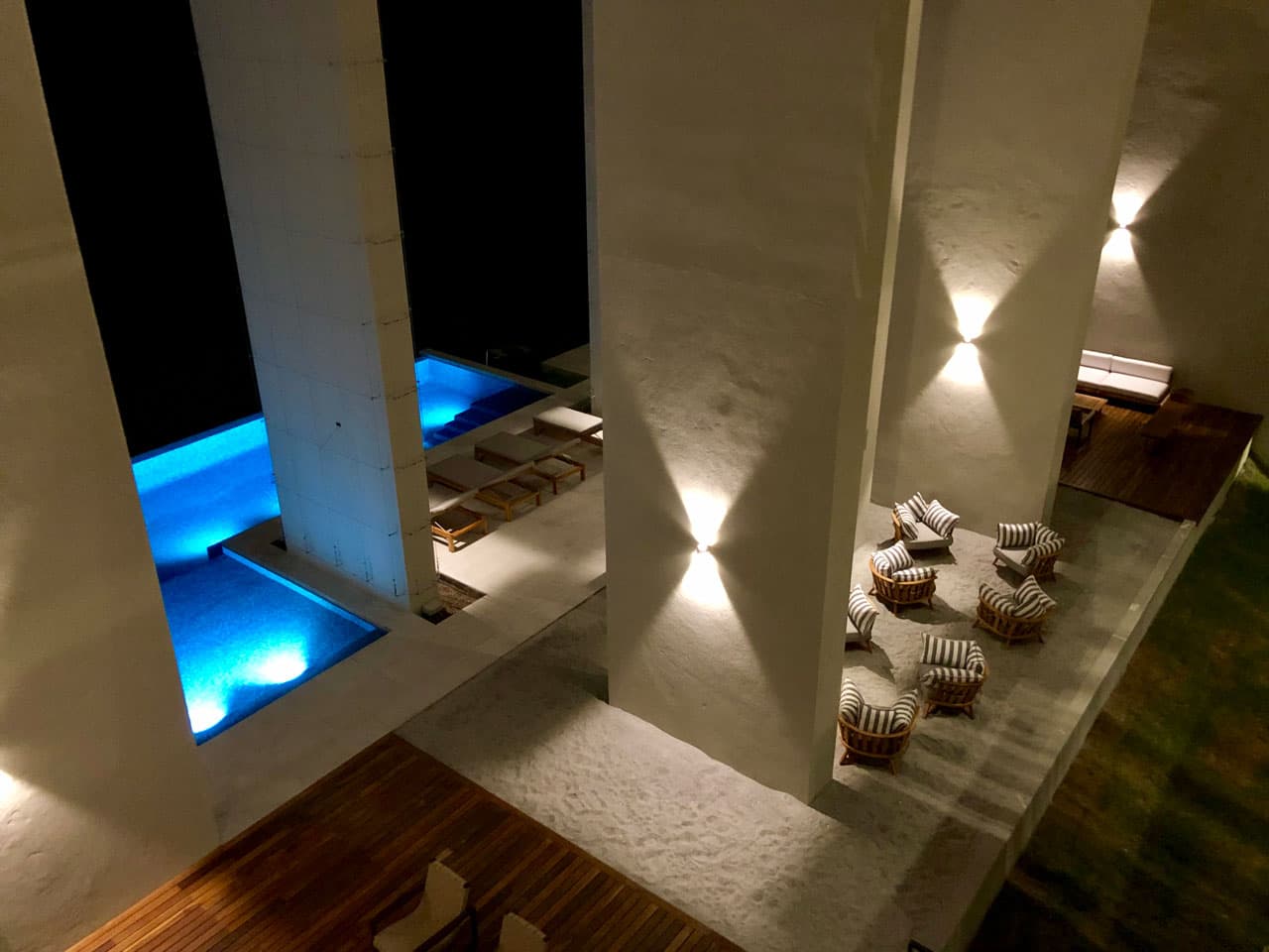 Illuminated pool and lounge at night at Solaria, Punta Caelo