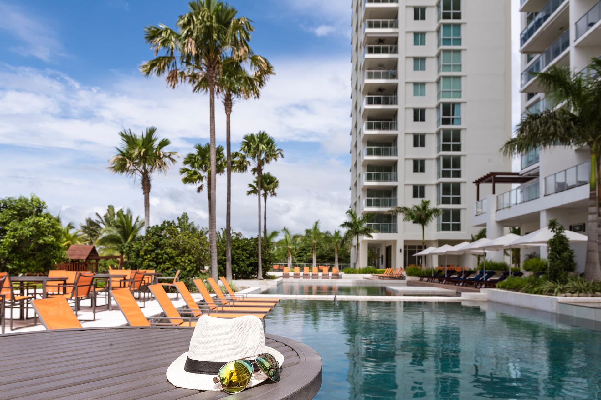 Riomar apartment tower rising above its palm-lined pool in San Carlos