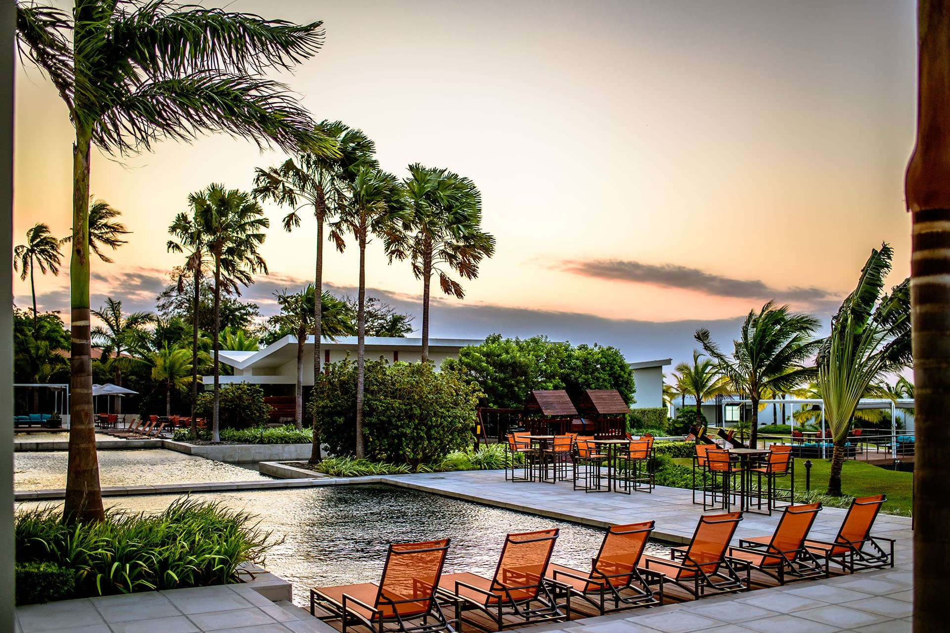 Riomar pool deck with orange loungers at sunset