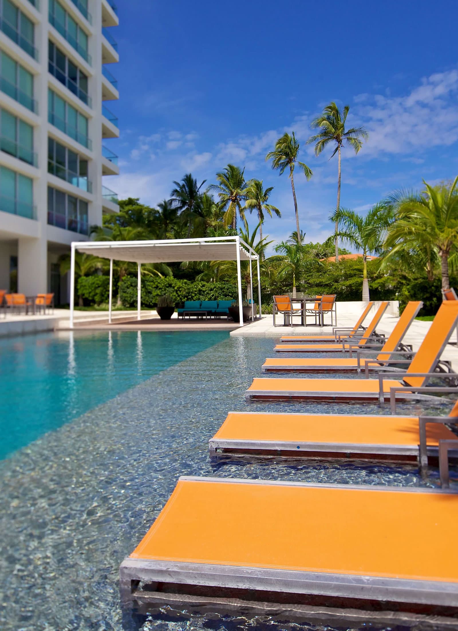 Shallow pool ledge with sun loungers beside a Riomar tower