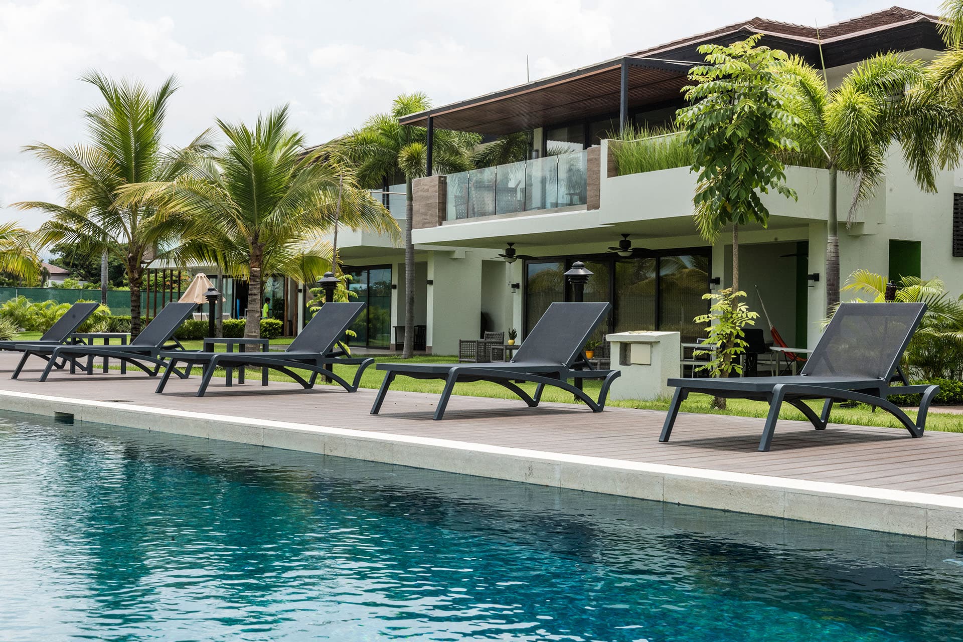 Pool deck with sun loungers in front of the Luceros townhouses