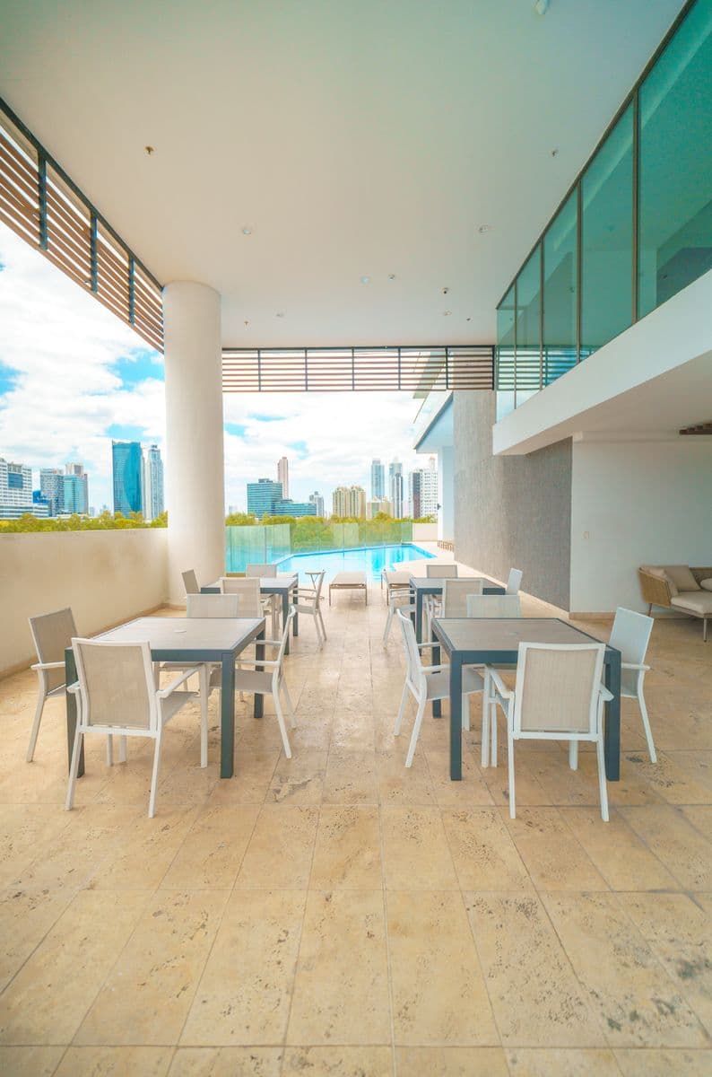 Covered terrace with dining tables overlooking the pool at Park Lane