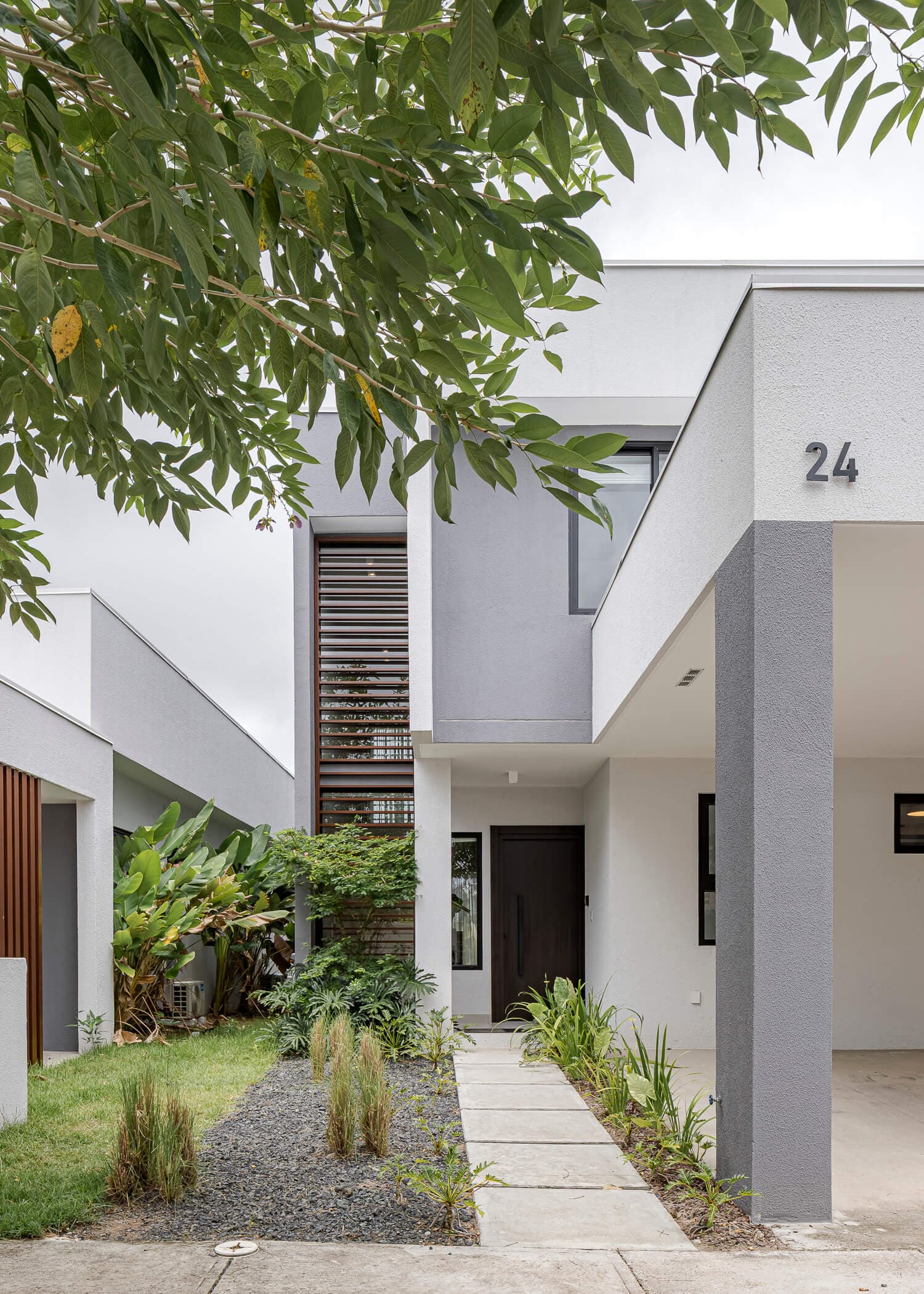 Entrance walkway and two-story facade of a house at Imaterra