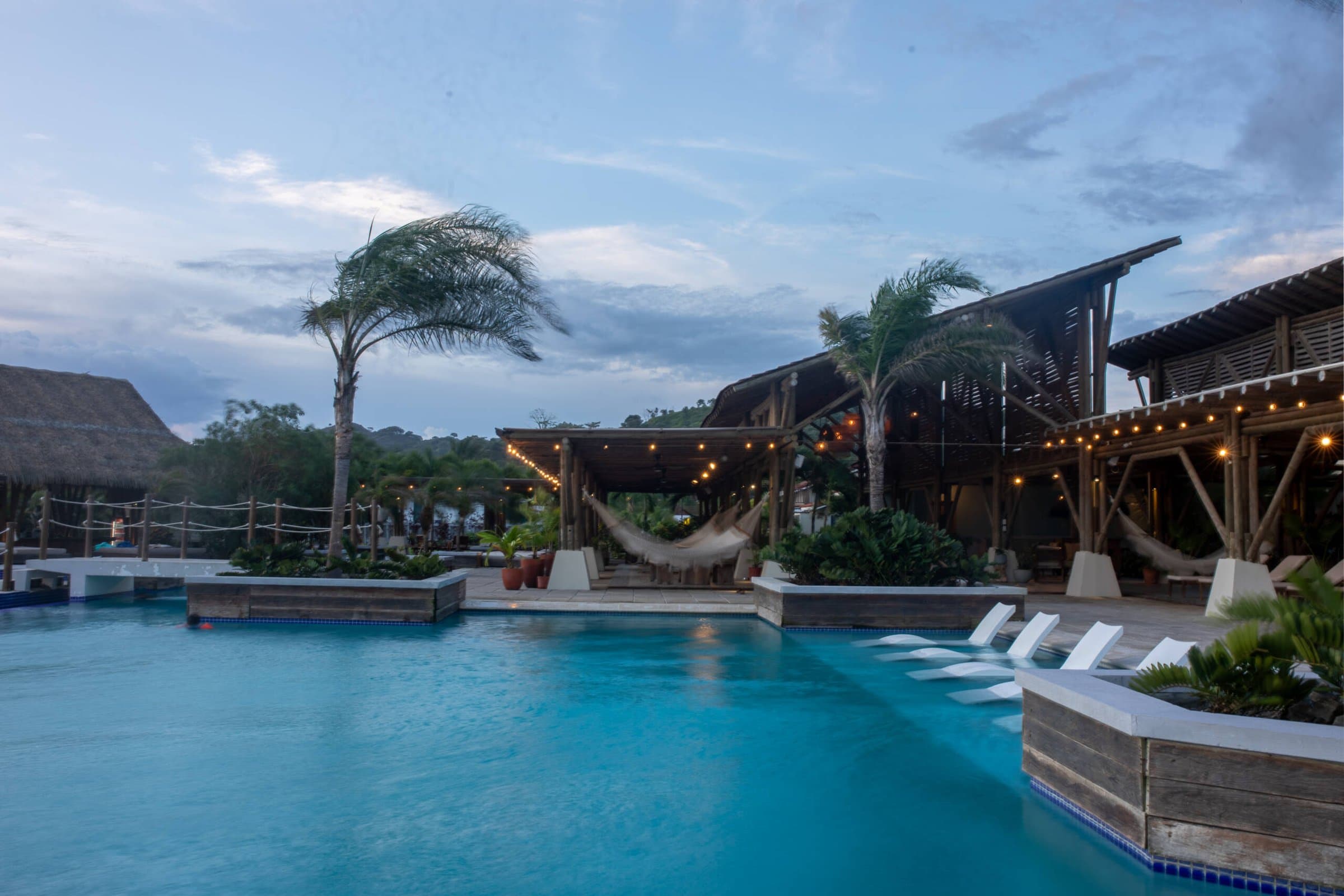 Blue Venao beach club pool with lounge beds and palms at dusk
