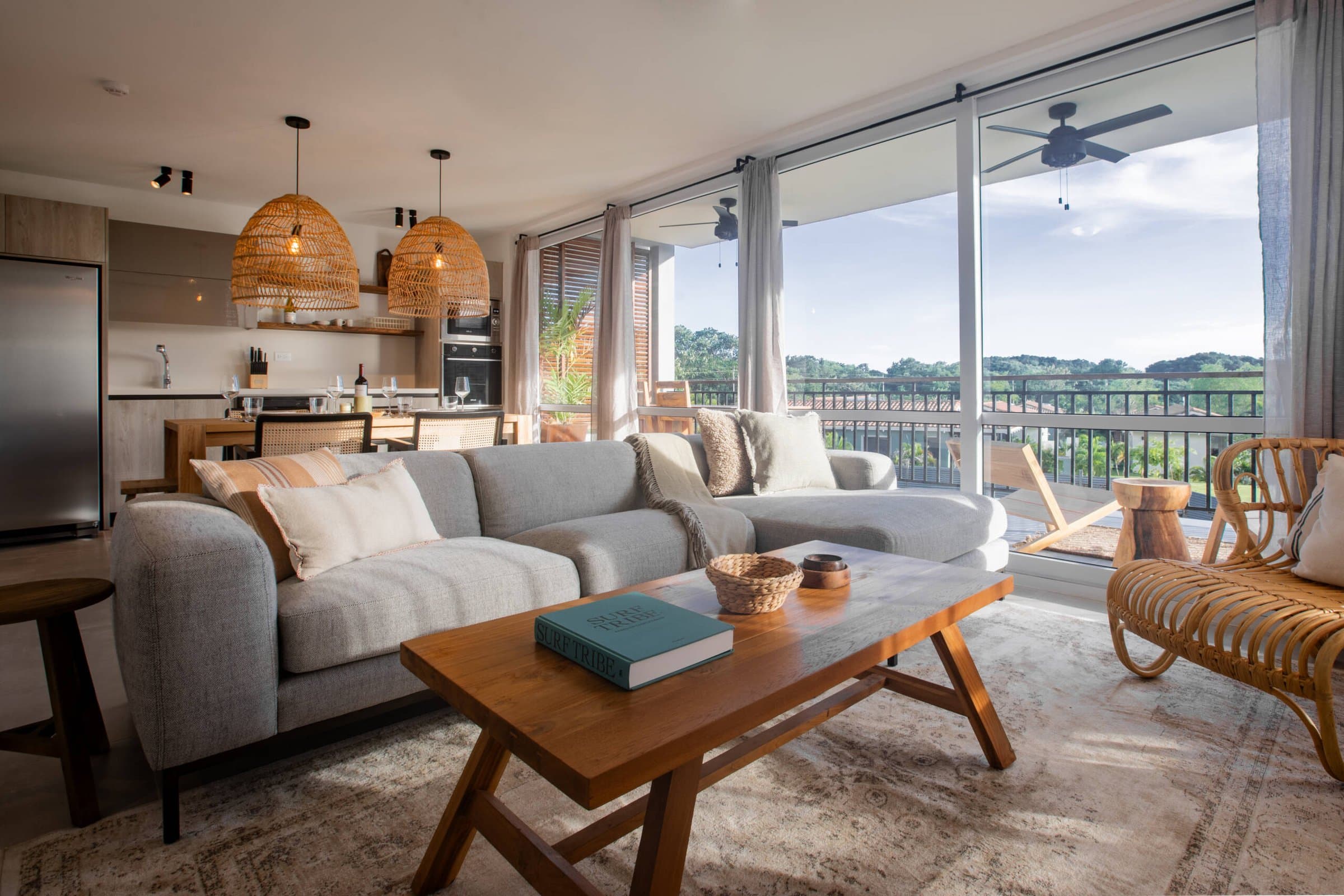 Living room and kitchen of a Blue Venao two-bedroom condo with floor-to-ceiling windows
