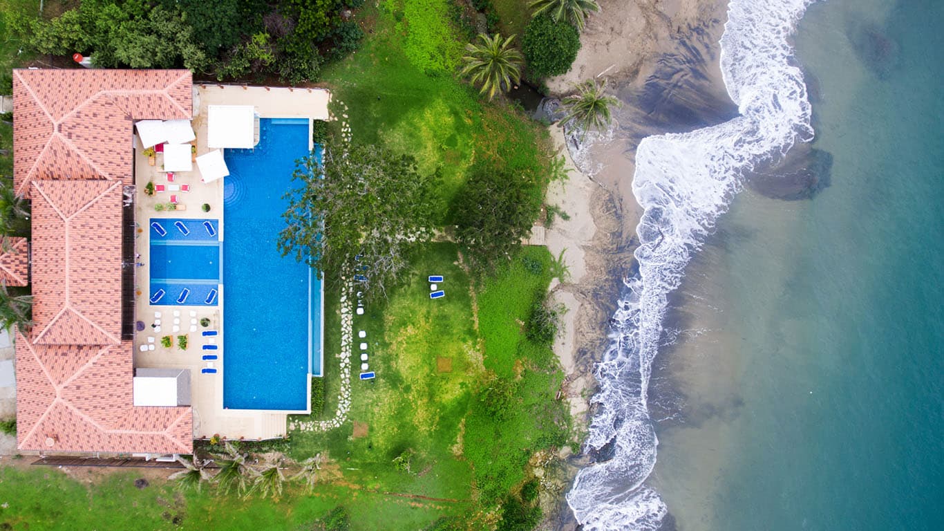 Aerial view of an Andromeda oceanfront villa with pool beside the shoreline in Pedasi