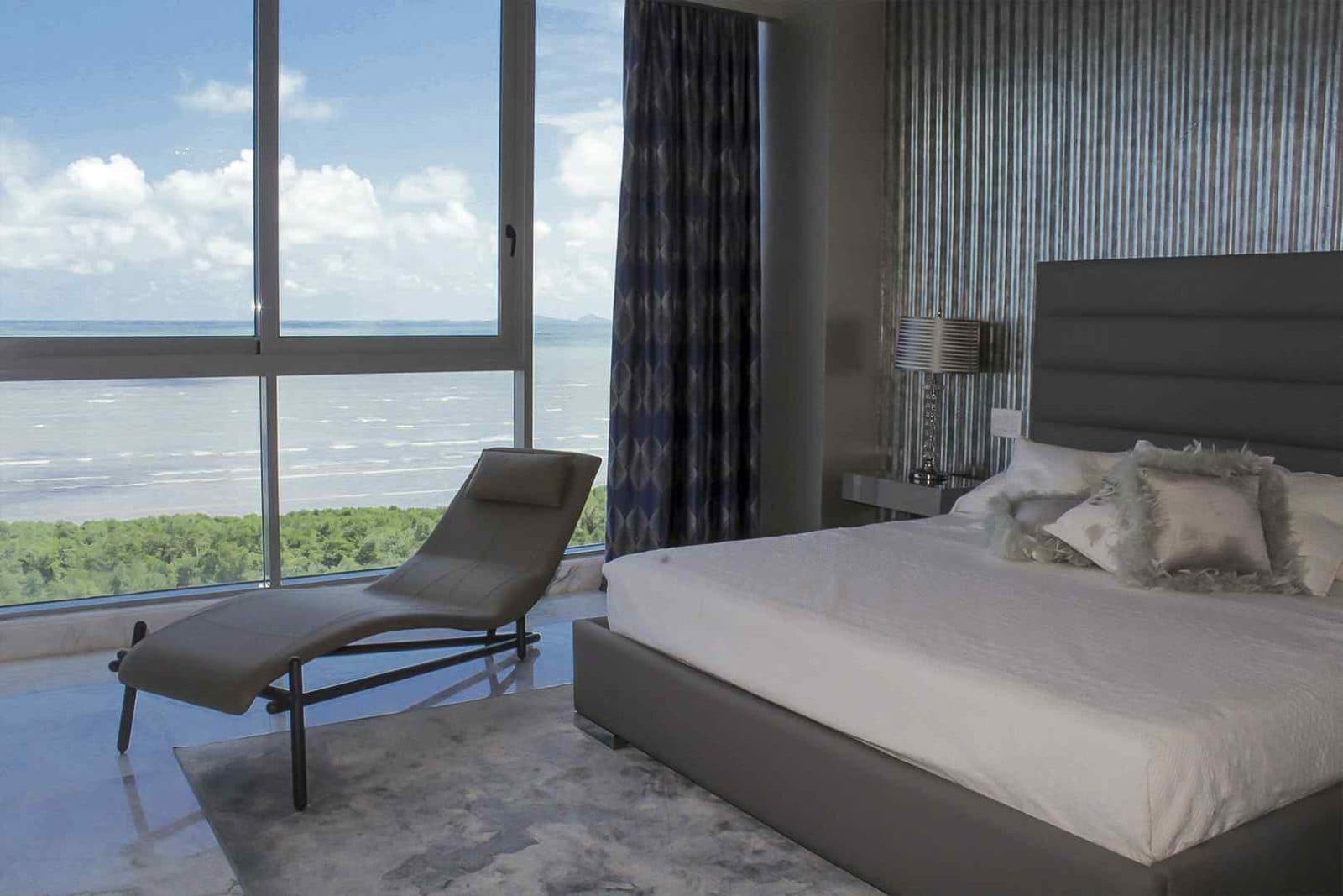 Master bedroom with floor-to-ceiling ocean view windows at Regalia