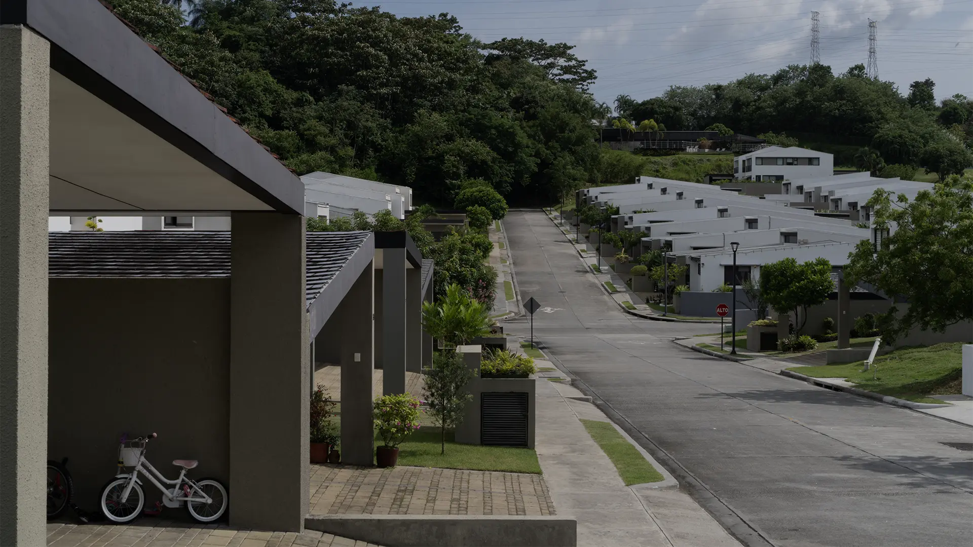Street view of BarrioAlto homes set against green hills