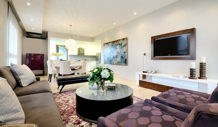 Living room with sectional sofa and open kitchen in a Greenview Residences apartment