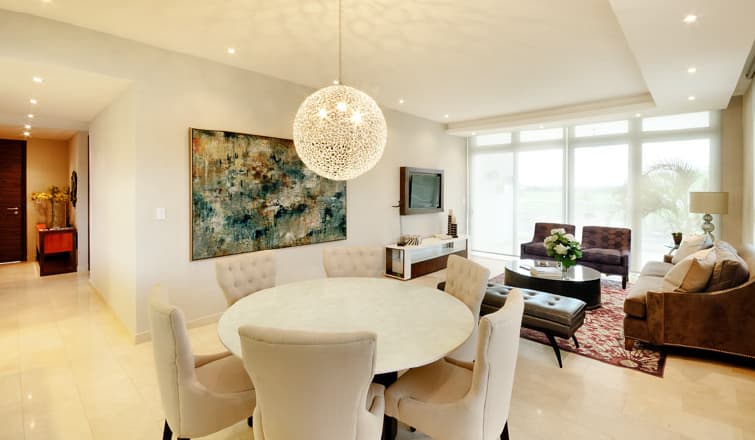Dining and living area with round table in a Greenview Residences apartment