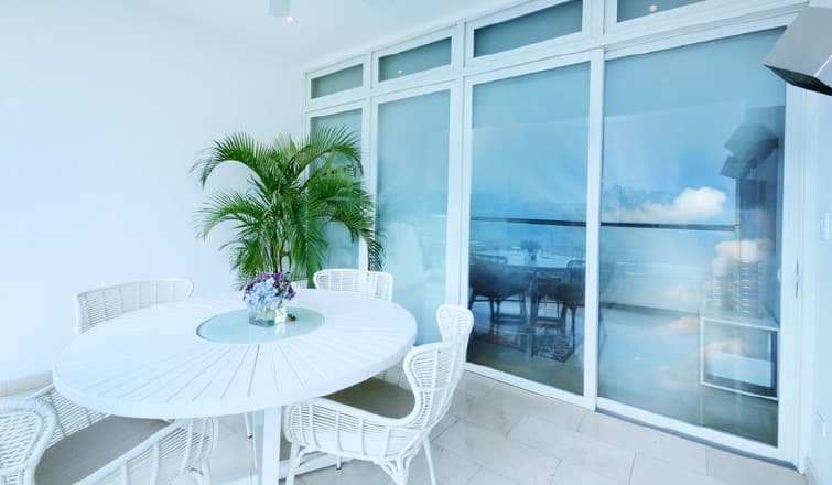 Enclosed balcony with white dining set in a Greenview Residences apartment
