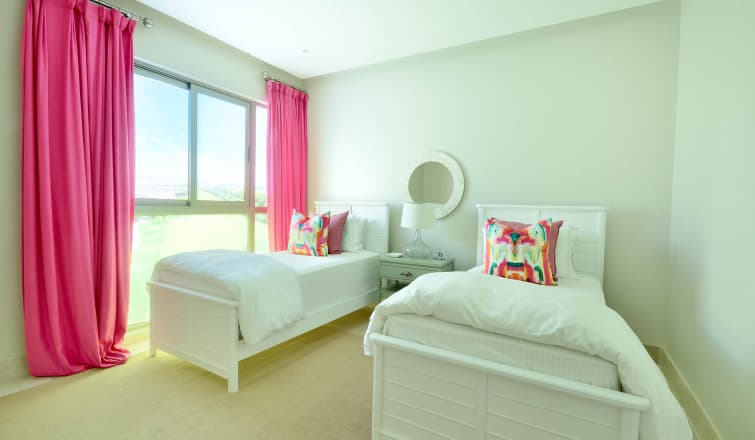 Twin bedroom with pink curtains in a Greengarden apartment