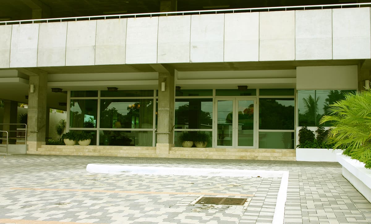 Glass-fronted lobby and paved motor court at PH Pradera