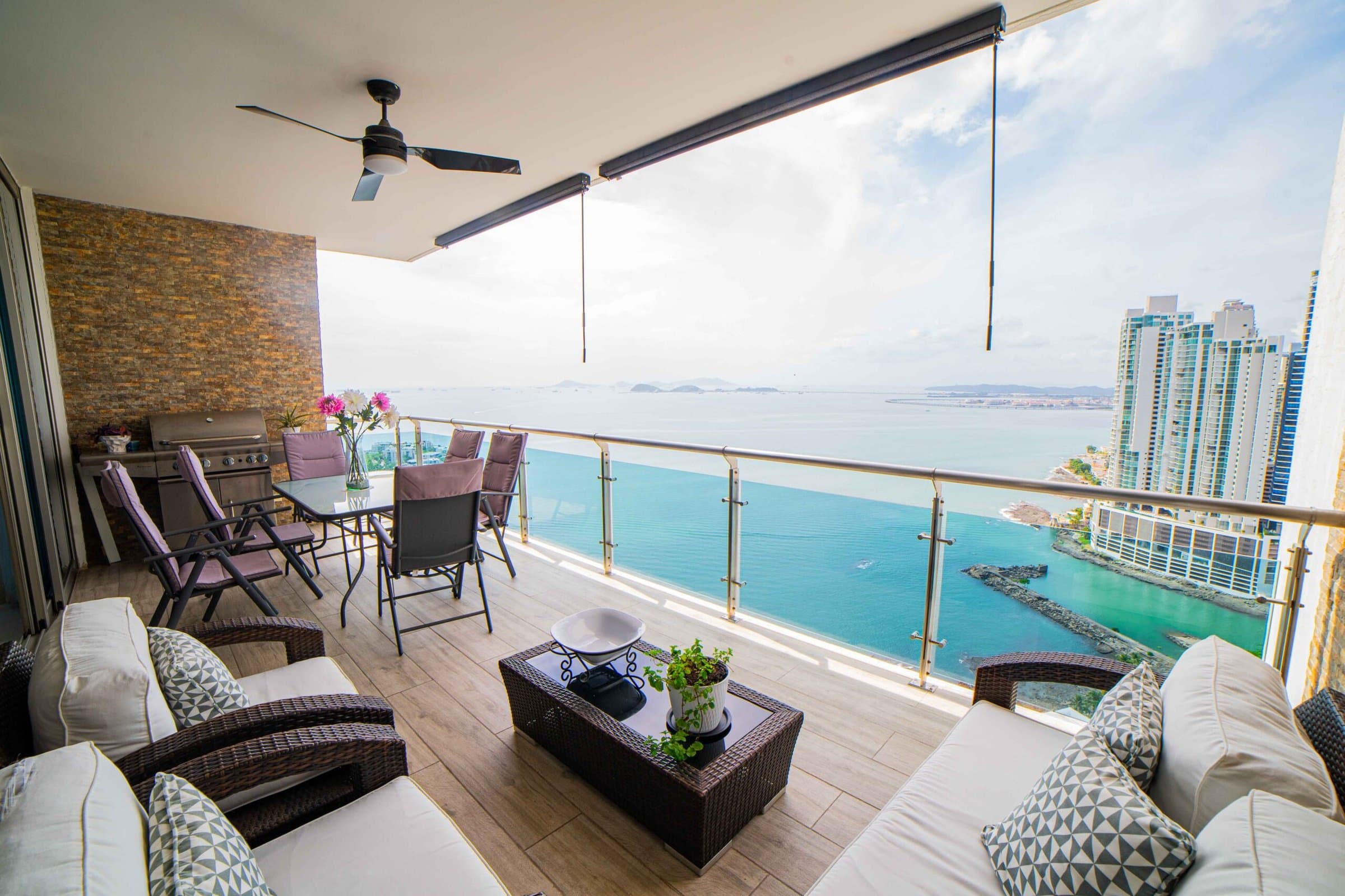 Photograph of a covered Aqualina terrace with lounge seating over the bay and Punta Pacifica