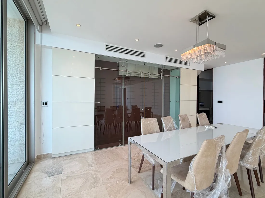 Photograph of a dining room with a glass wine cellar in an Aqualina apartment, Punta Pacifica