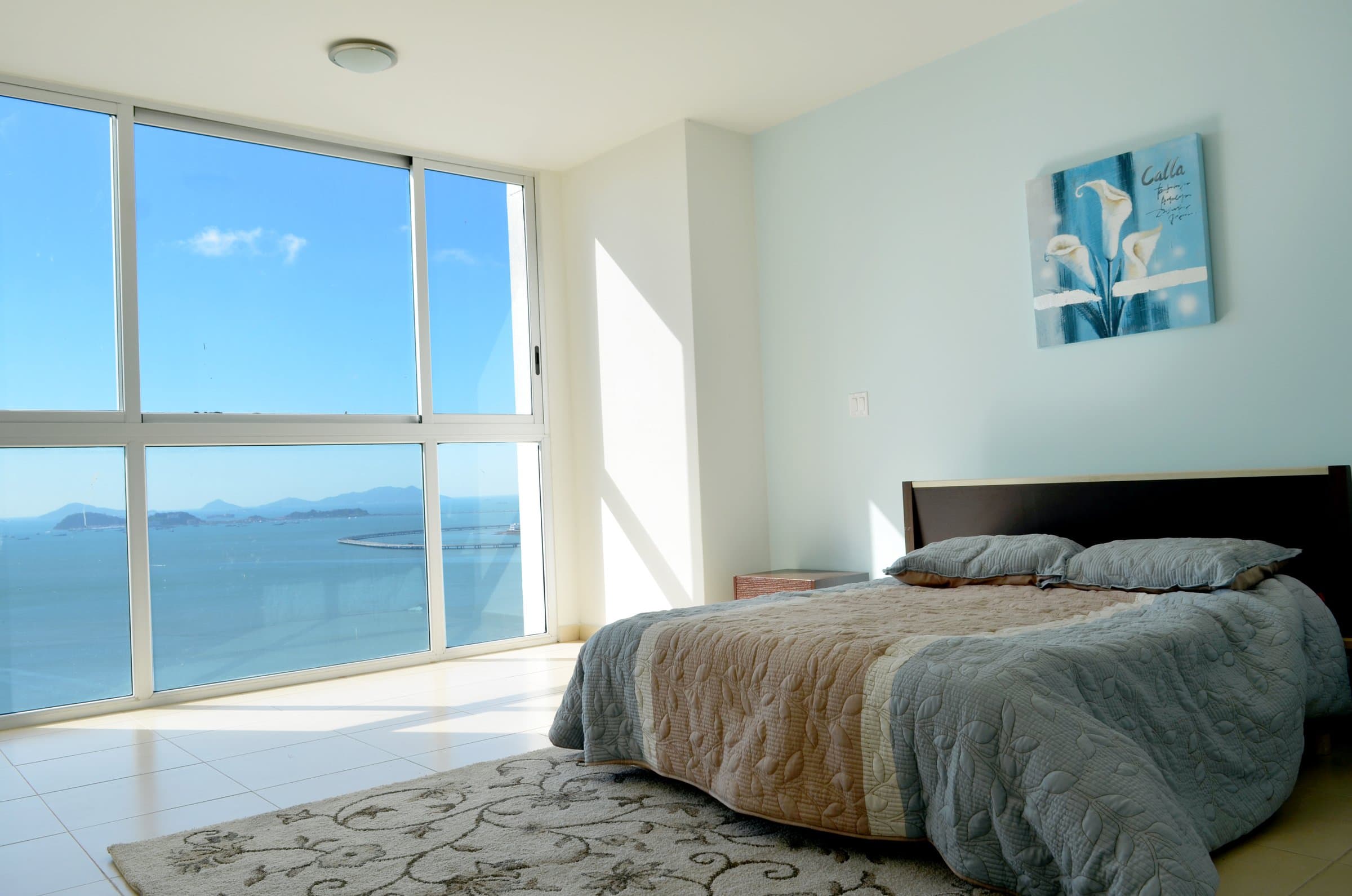 Waters on the Bay apartment bedroom with floor-to-ceiling windows over the bay