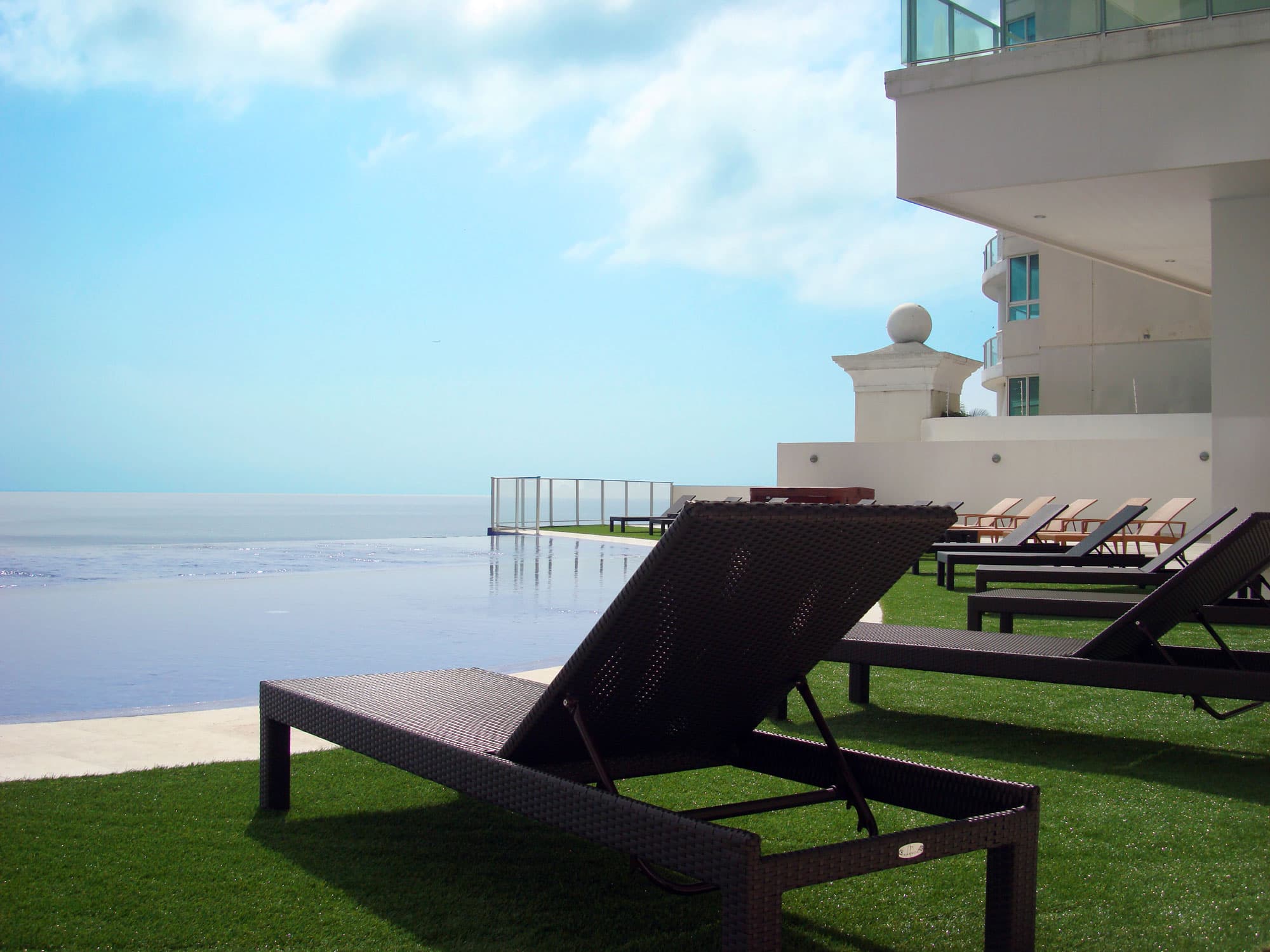 Oasis on the Bay pool terrace with sun loungers facing the Pacific