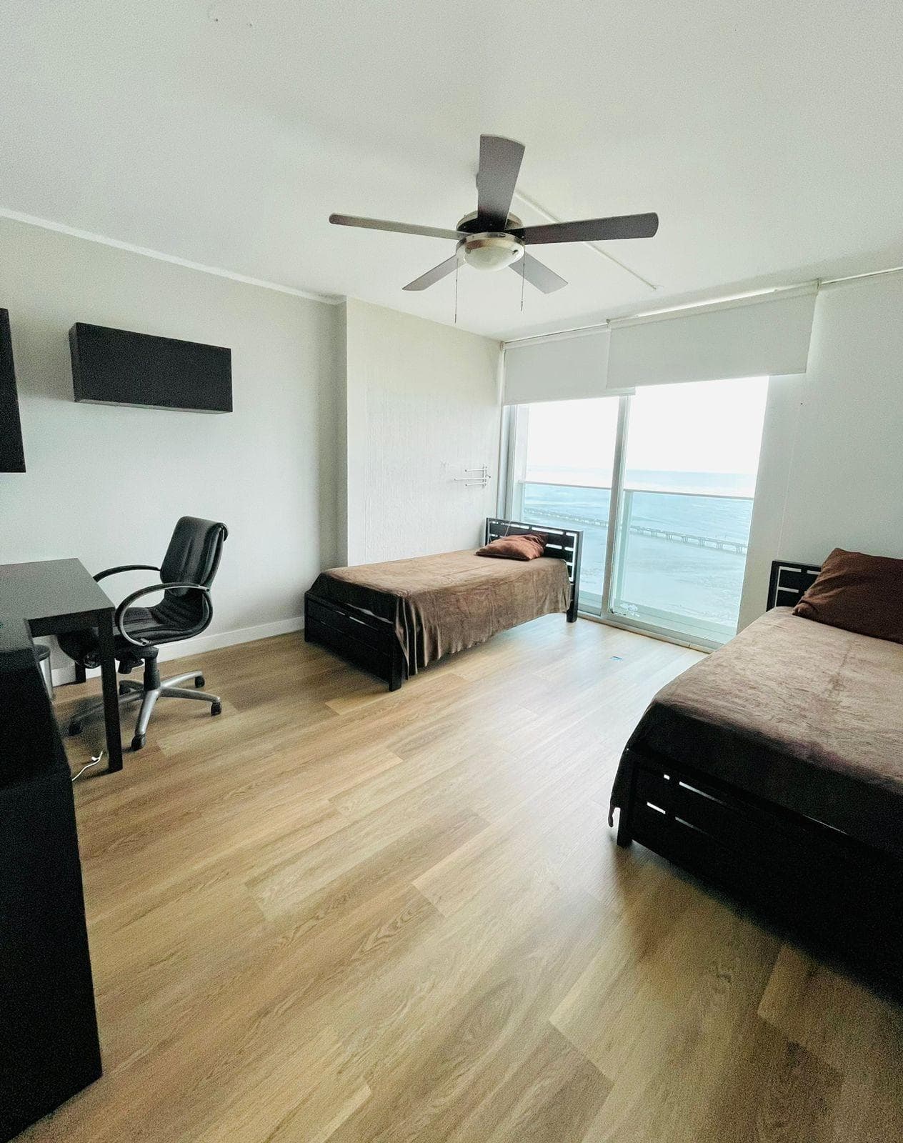Bedroom with wood floors and ocean view in a Nautica apartment