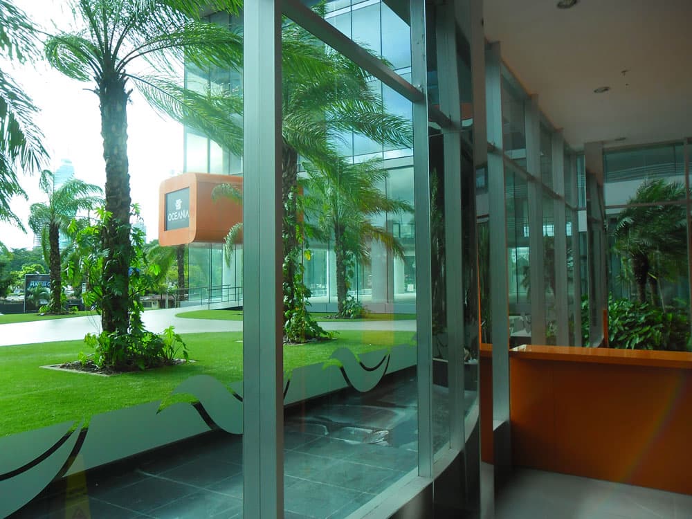 Oceania Business Plaza glass-walled lobby facing the garden