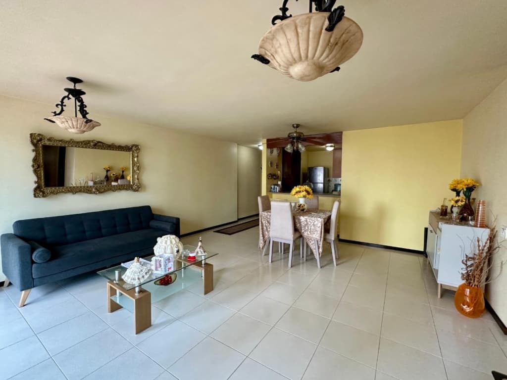 Living room of a Pacific Wind apartment with tiled floors and dining area