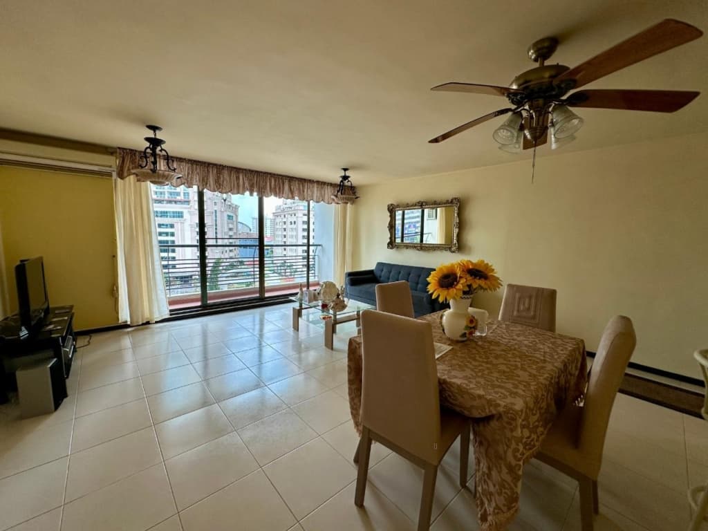 Living and dining area of a Pacific Wind apartment with city-view windows