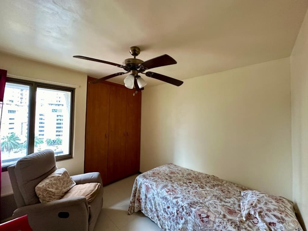Bedroom of a Pacific Wind apartment with built-in wardrobe and city view