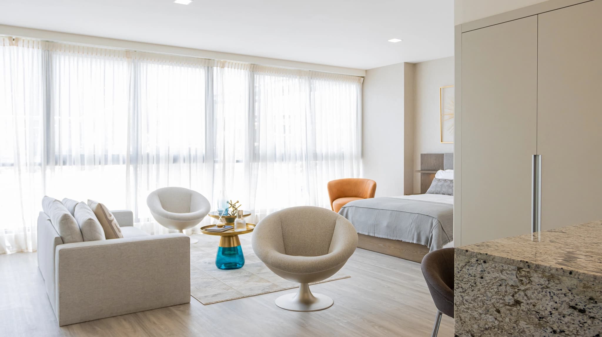 Living area and bedroom of a furnished Arcadia del Este condo-suite