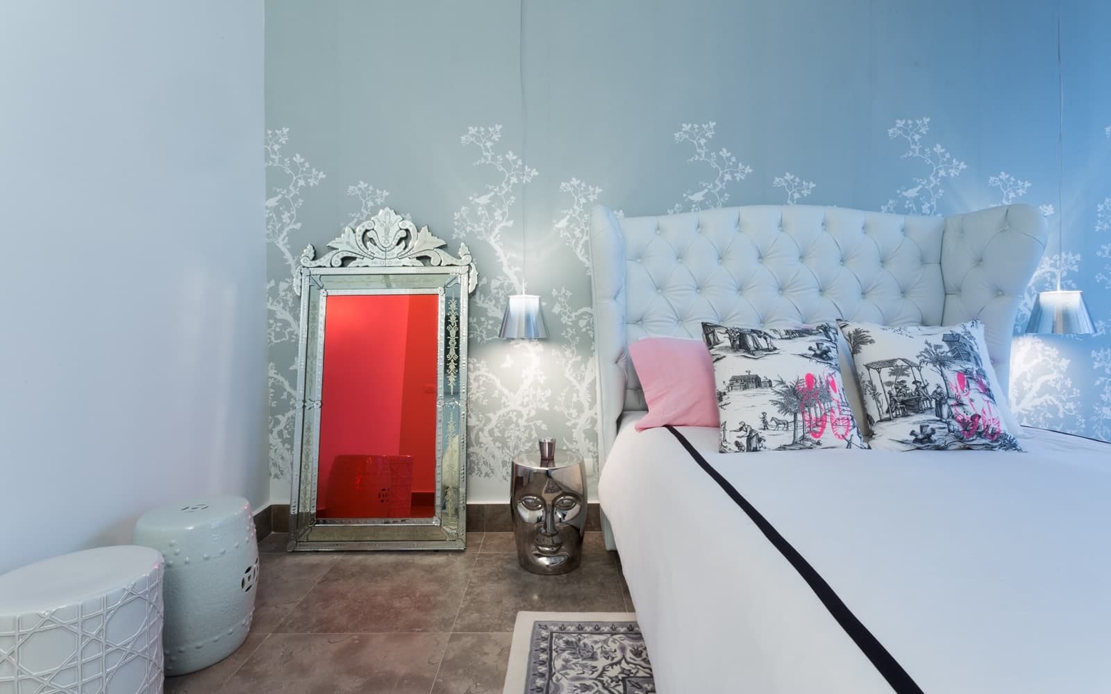 Bedroom with a tufted headboard and Venetian mirror in a Yoo Panama residence