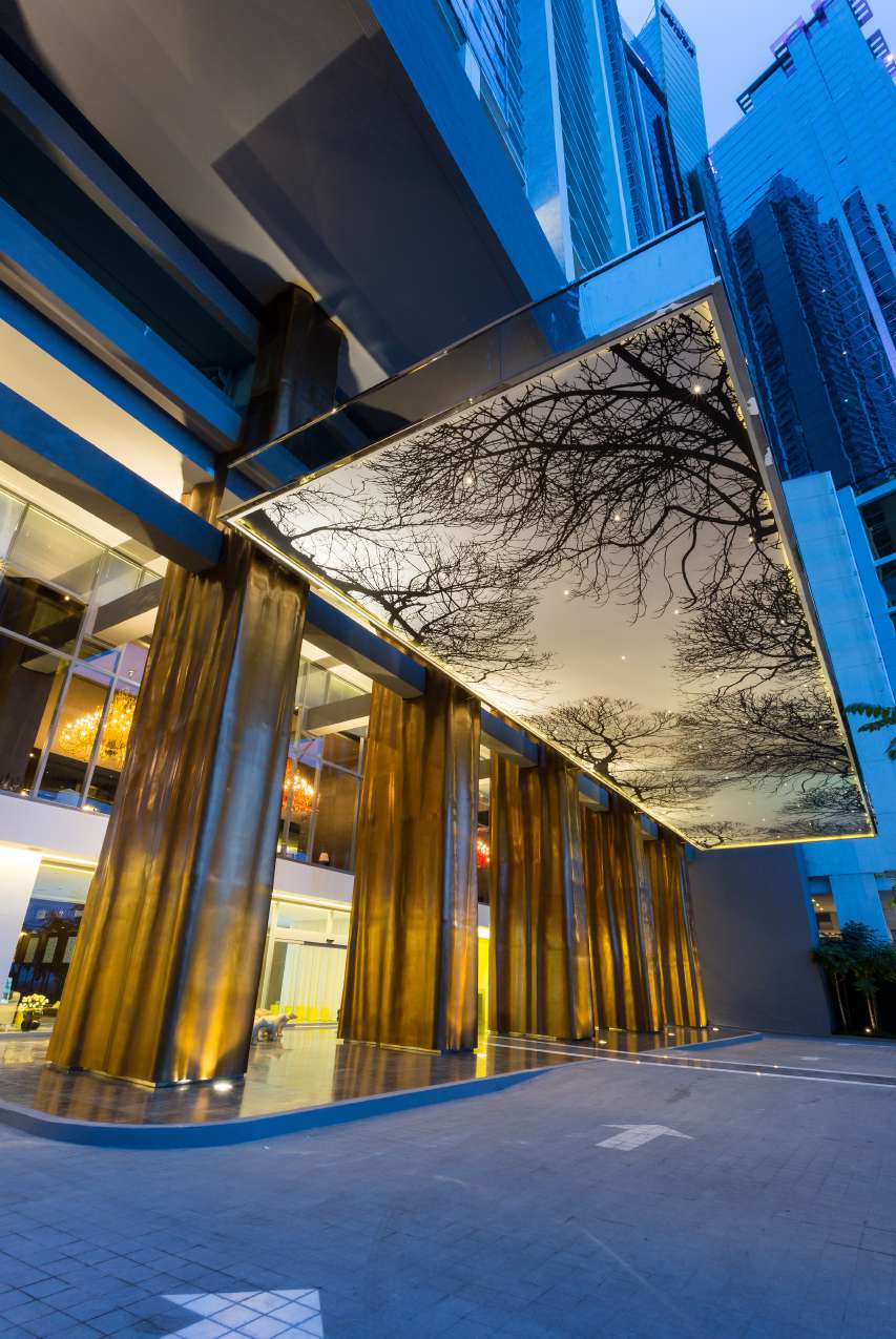 Entrance canopy and bronze columns at the base of Yoo Panama & Arts Tower on Avenida Balboa
