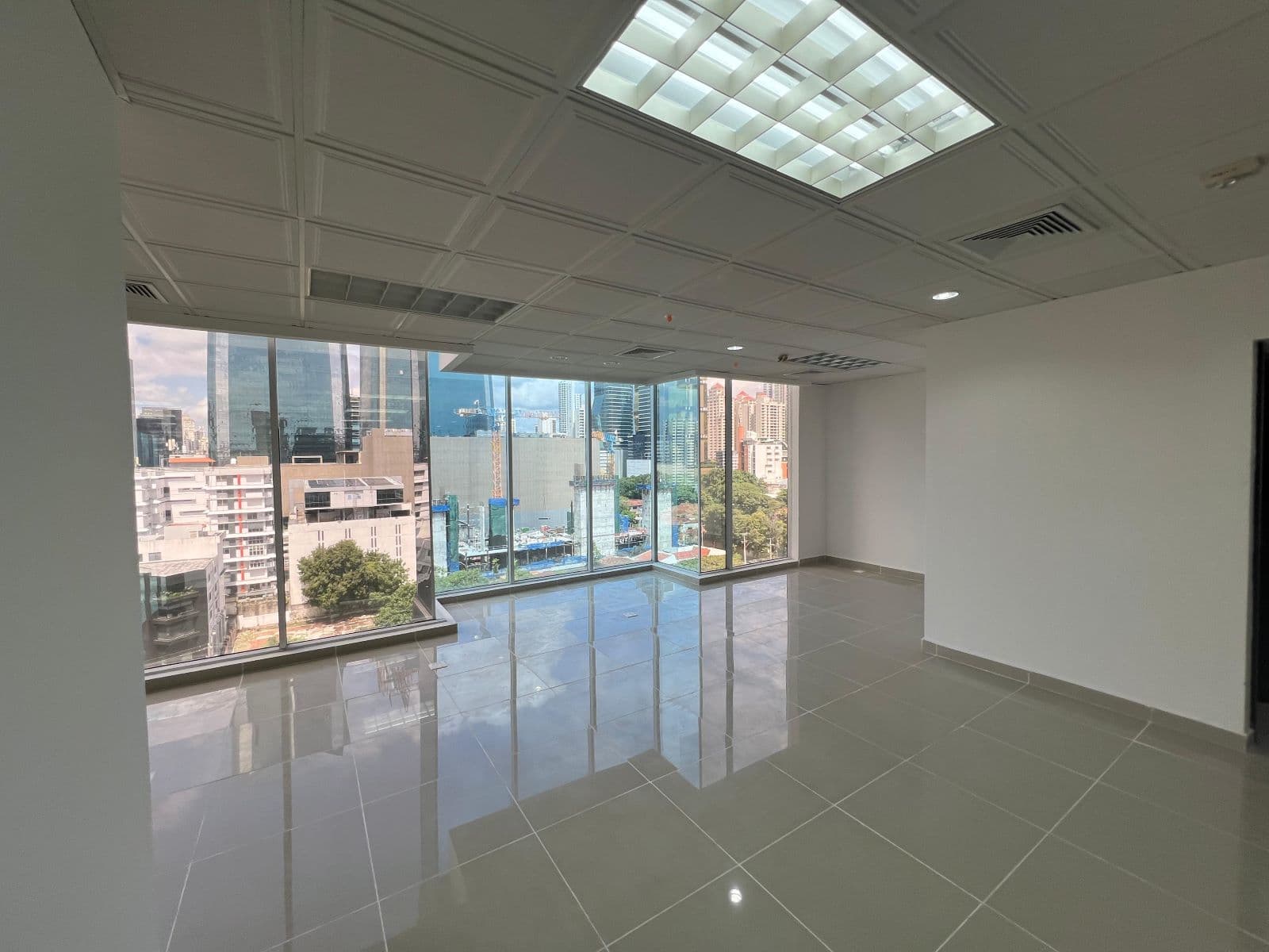 Open office floor with a glass curtain wall overlooking Obarrio in Office One Tower, Panama City
