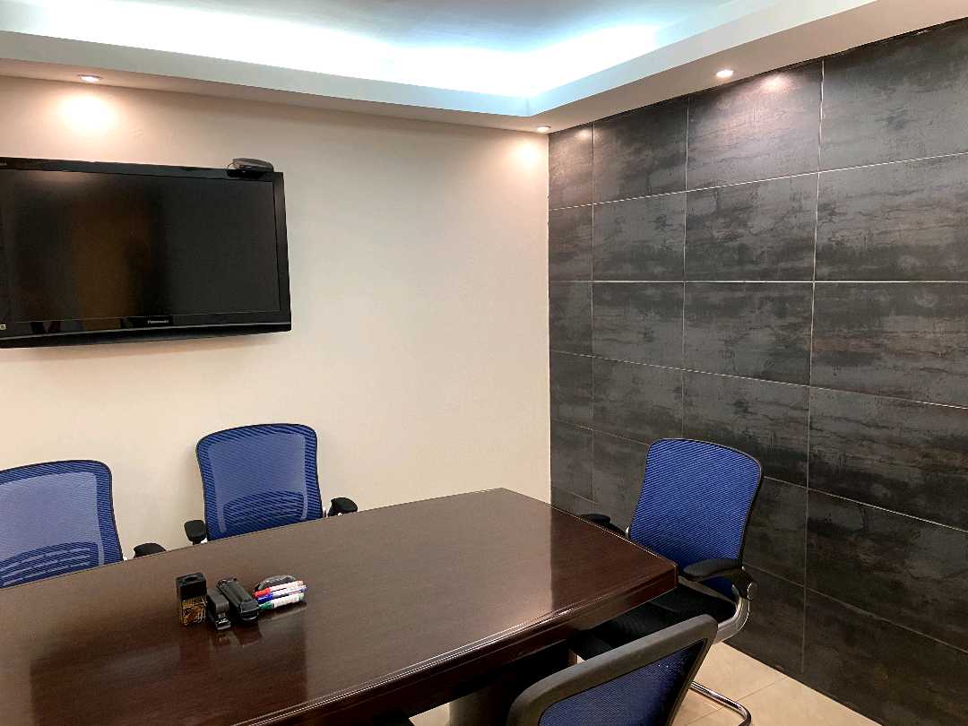 Meeting room with a wood table and stone accent wall in an office at Hi-Tech Plaza, Obarrio, Panama City