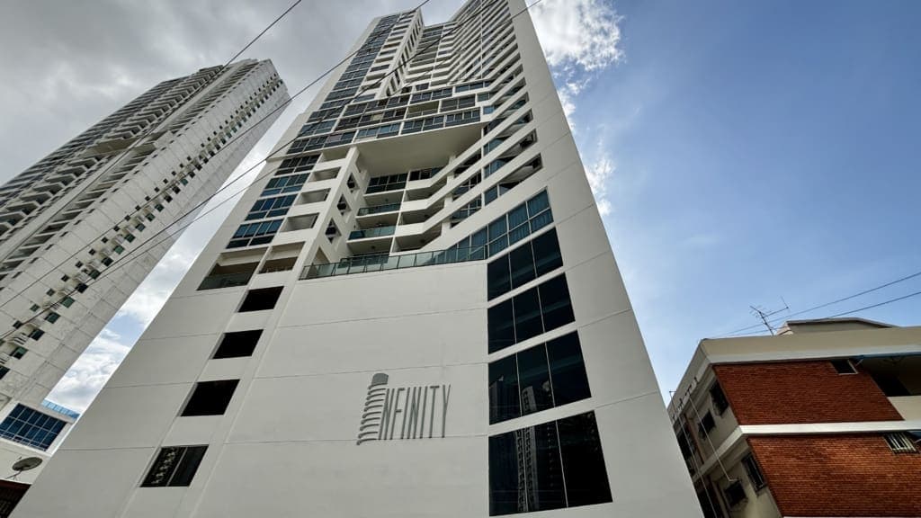 Upward view of the white PH Infinity tower facade with its Infinity sign, San Francisco, Panama City