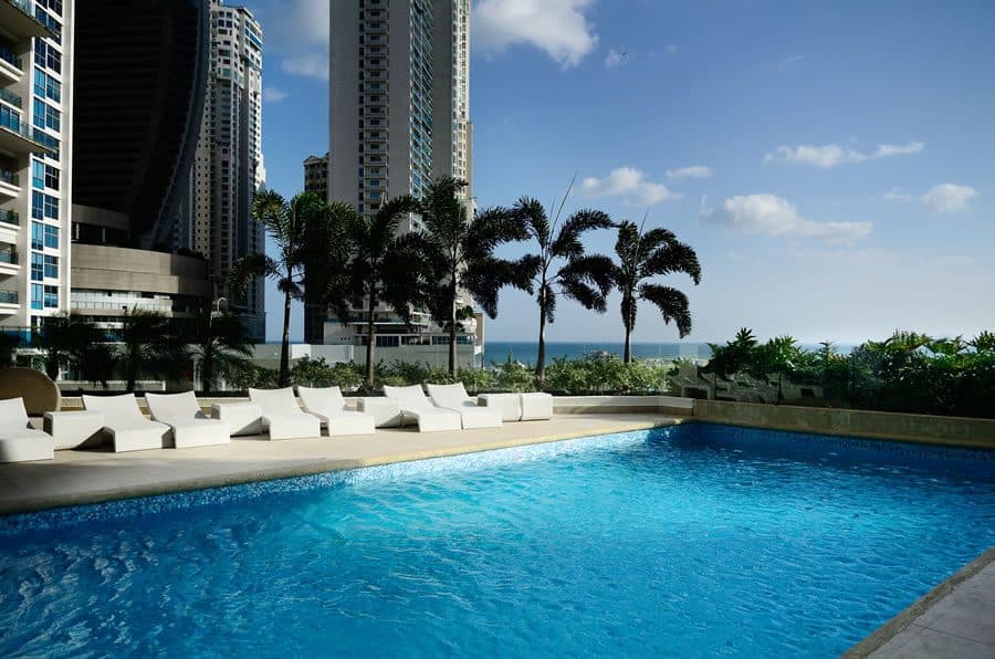 Outdoor swimming pool and sun loungers overlooking the ocean at Q Tower, Punta Pacifica