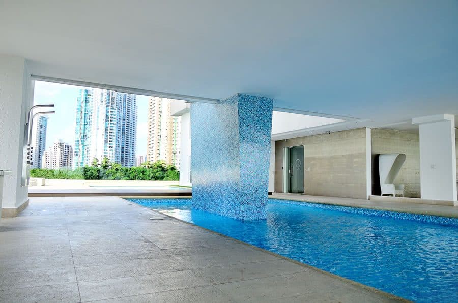 Semi-covered swimming pool with a blue mosaic-tiled column at Q Tower, Punta Pacifica