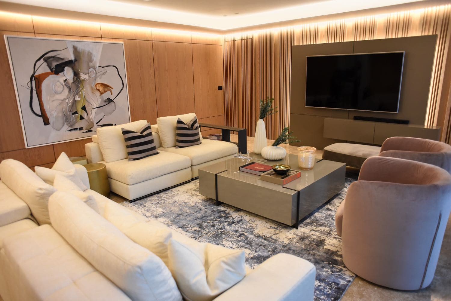Furnished living room with cream sofas and wood-panelled walls in a Q Tower apartment