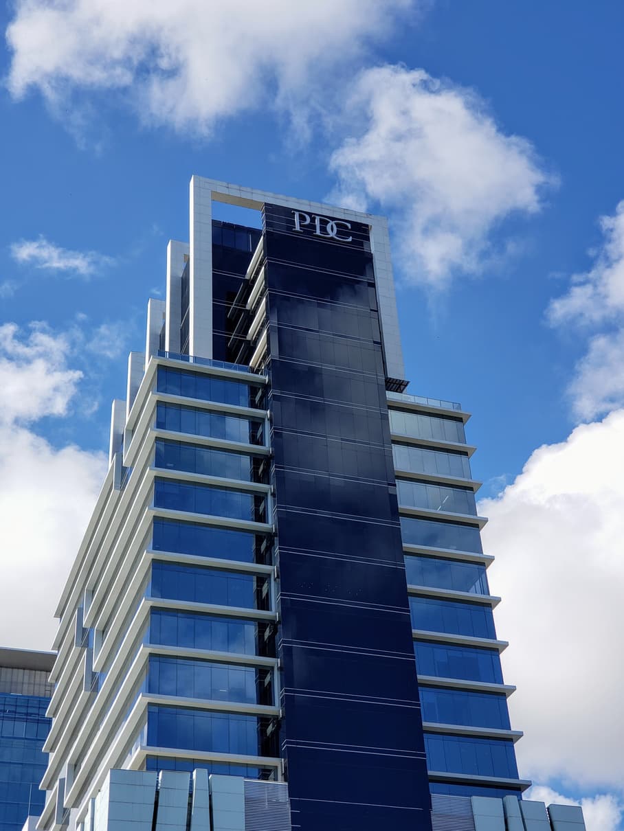 Blue glass tower facade of PDC Panama Design Center against the sky, Obarrio, Panama City