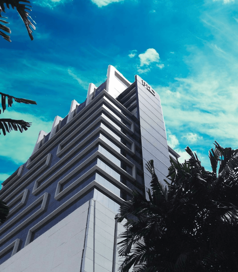 Stepped facade corner of PDC Panama Design Center framed by palm trees