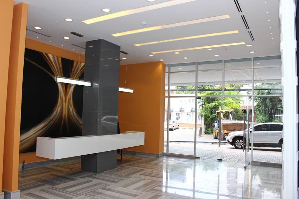 Lobby reception desk with orange feature wall at PDC Panama Design Center