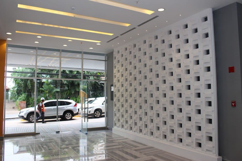 Glass-fronted entrance lobby with white lattice wall at PDC Panama Design Center