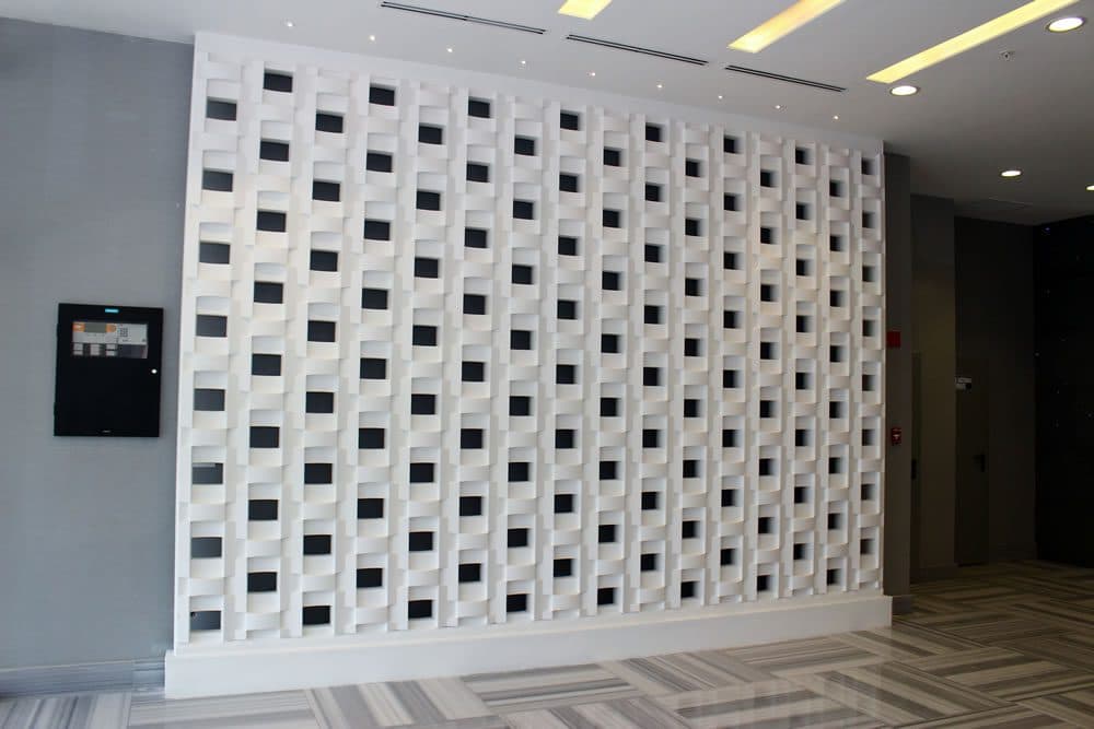 White sculpted lattice wall in the lobby of PDC Panama Design Center