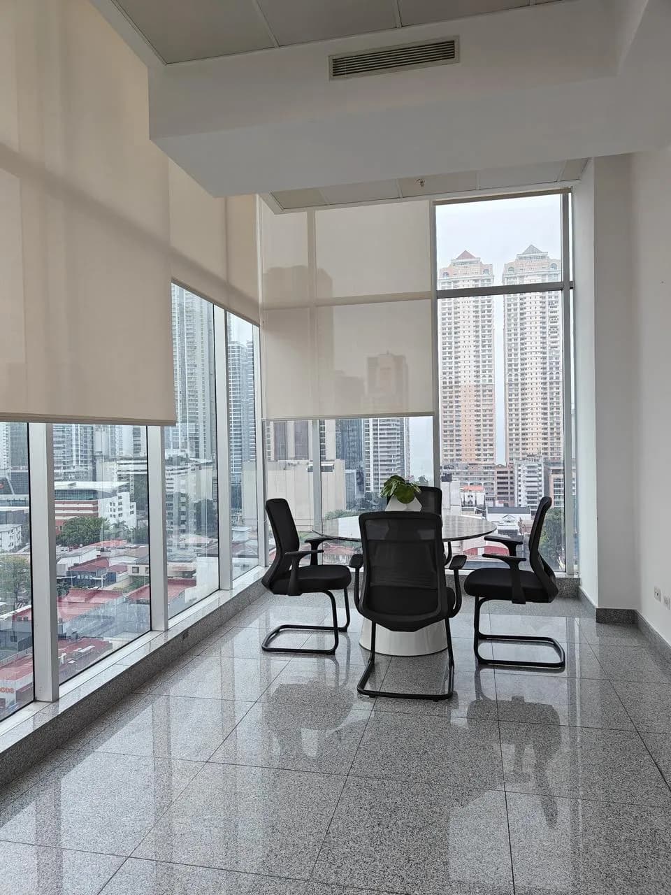 Corner meeting area with floor-to-ceiling glass and views of the Marbella towers in Habitats Plaza, Panama City
